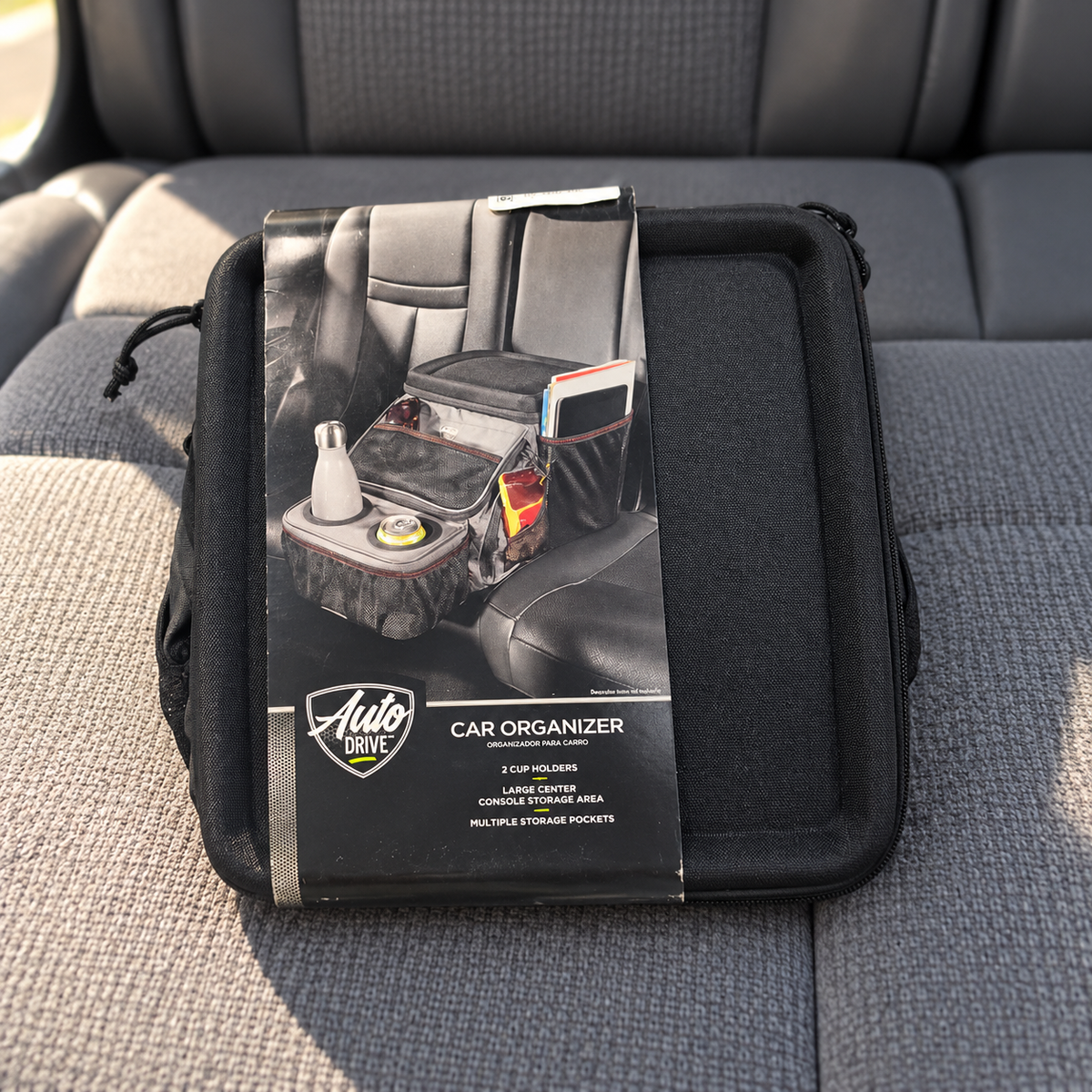AI-generated lifestyle illustration: folded Auto Drive organizer in its original display sleeve on a parked car's rear seat; pictured accessories and scene props are not included.