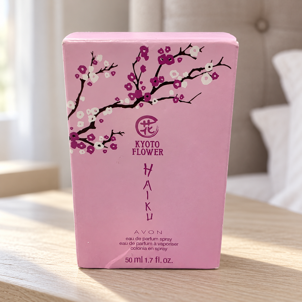 AI-generated lifestyle illustration: closed Avon Haiku Kyoto Flower 50 mL / 1.7 fl oz carton with visible creases on a bedside shelf; furnishings and decorative props not included.