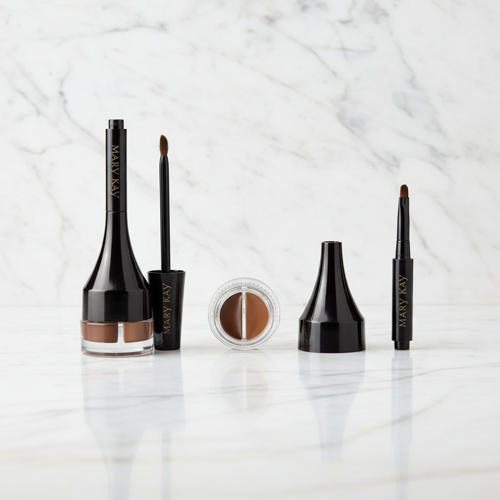 Mary Kay brow kit featuring a black eyebrow pomade bottle with a clear base showing the brown product, a small round pot of brow powder, a black cap, and a black brow pencil on a white background.