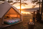 Outdoor sunset camping scene with child's colorful airbed inside a tent