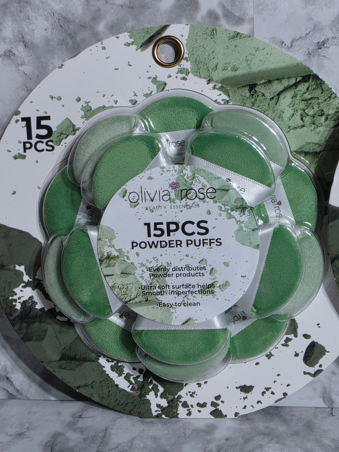 Pack of Olivia Rose powder puffs on a decorative tray with green and white design.