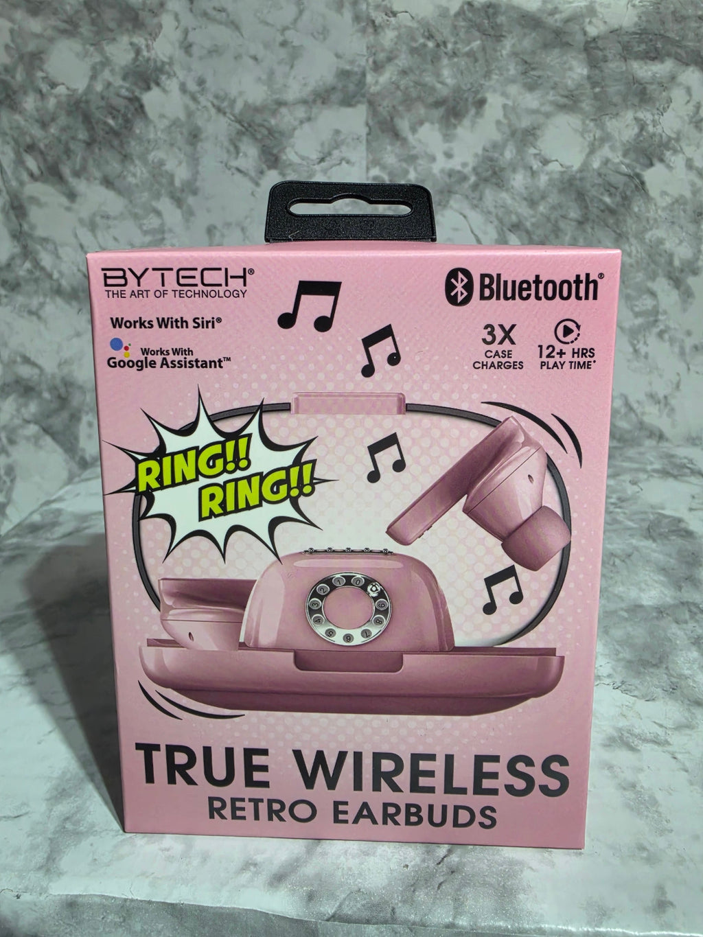 Pink packaging of true wireless retro earbuds on a gray surface