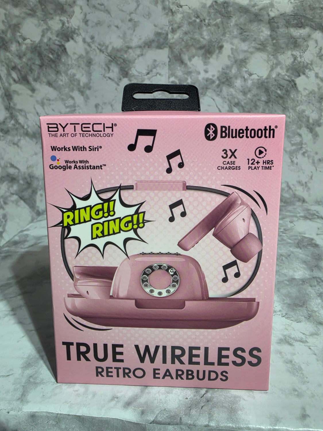 Pink packaging of true wireless retro earbuds on a gray surface