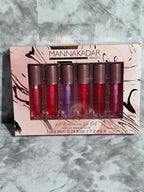 Set of five lip glosses in a branded packaging on a marble surface