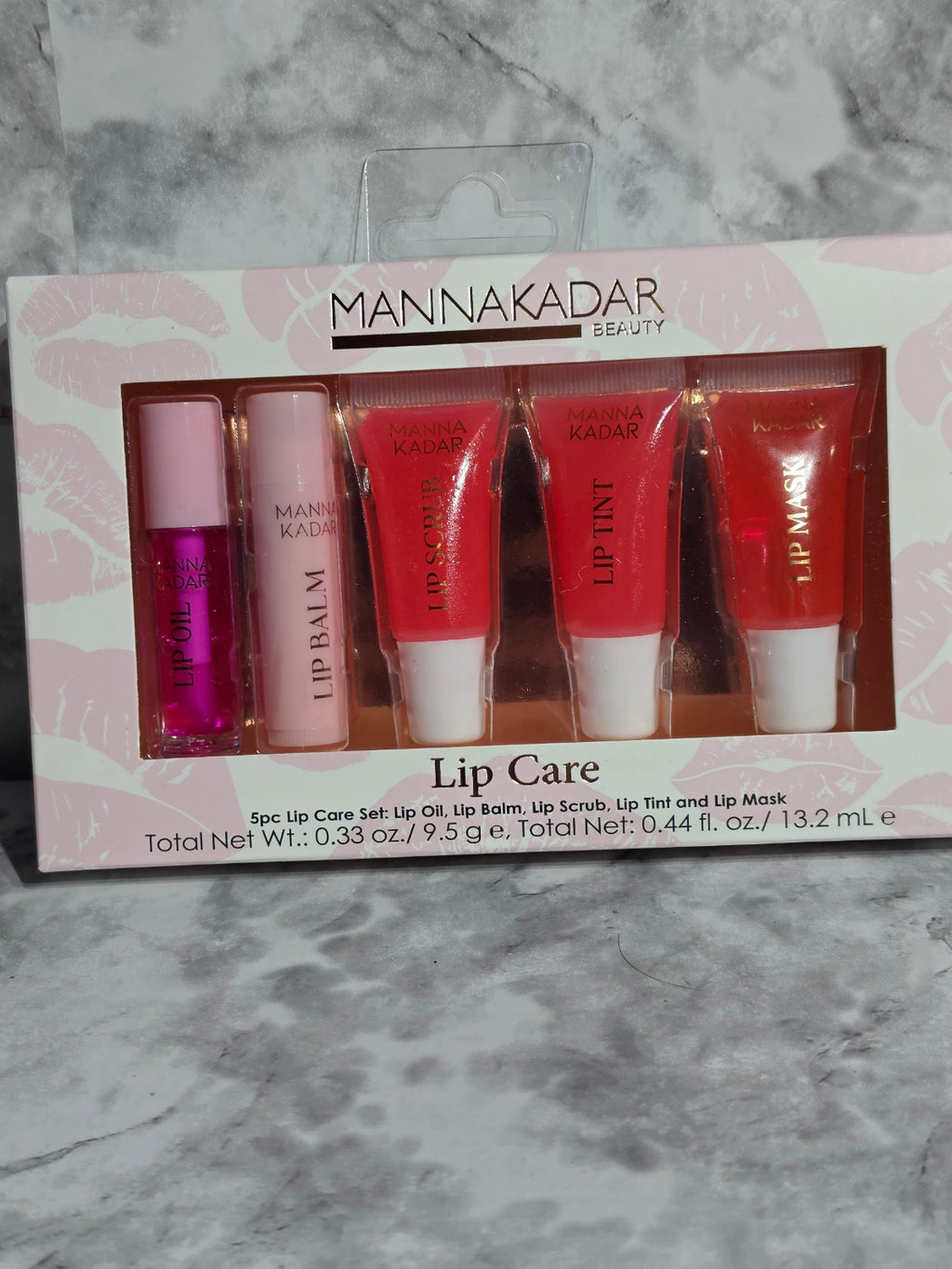 Set of lip care products in a box with 'Mannakadar' branding on a marble surface.