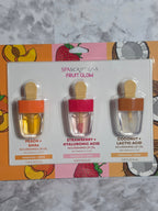 Set of lip oil containers with packaging on a marble surface