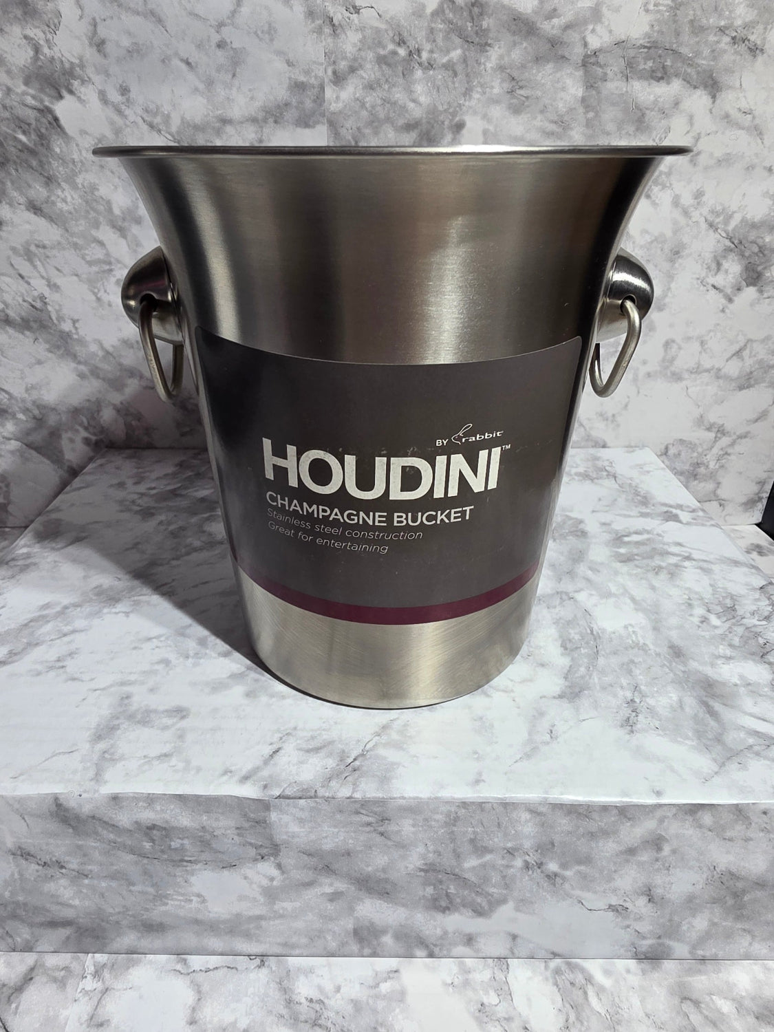 Stainless steel champagne bucket with Houdini branding on a marble surface