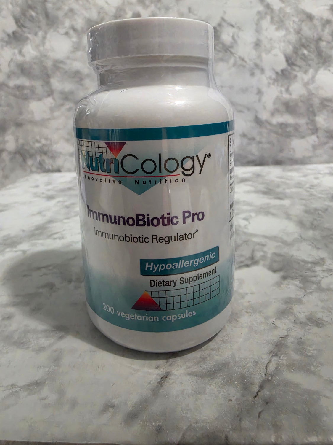 Supplement bottle labeled 'IntegroBiotic Pro' on a marble surface
