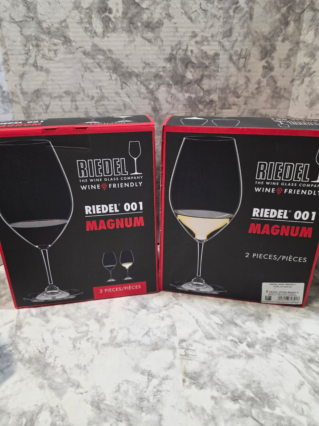 Two boxes of Riedel wine glasses on a marble surface