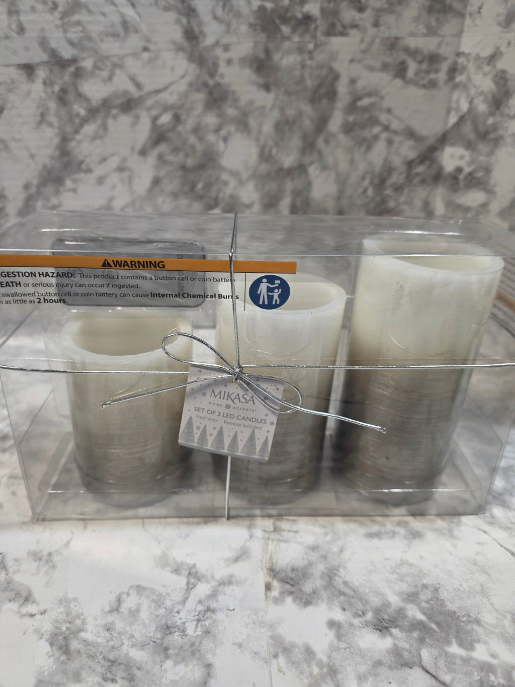 Two candles in a clear packaging on a marble surface