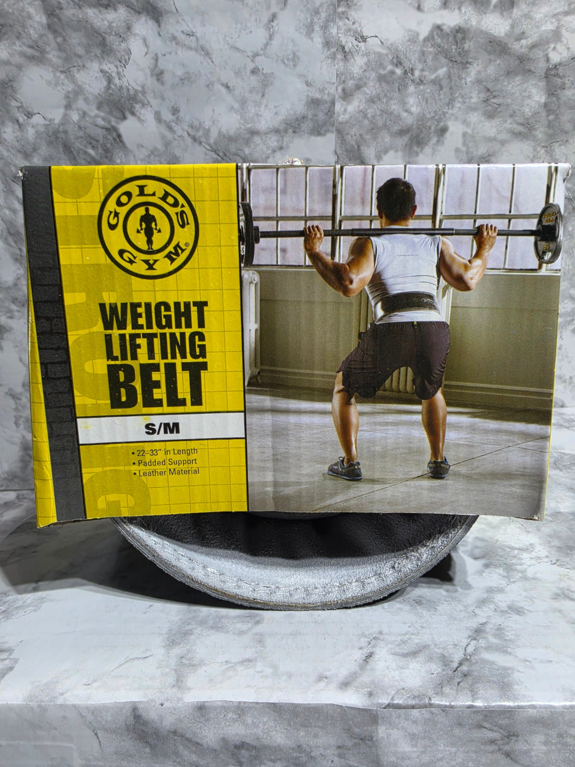 Weight lifting belt packaging with a person exercising in the background