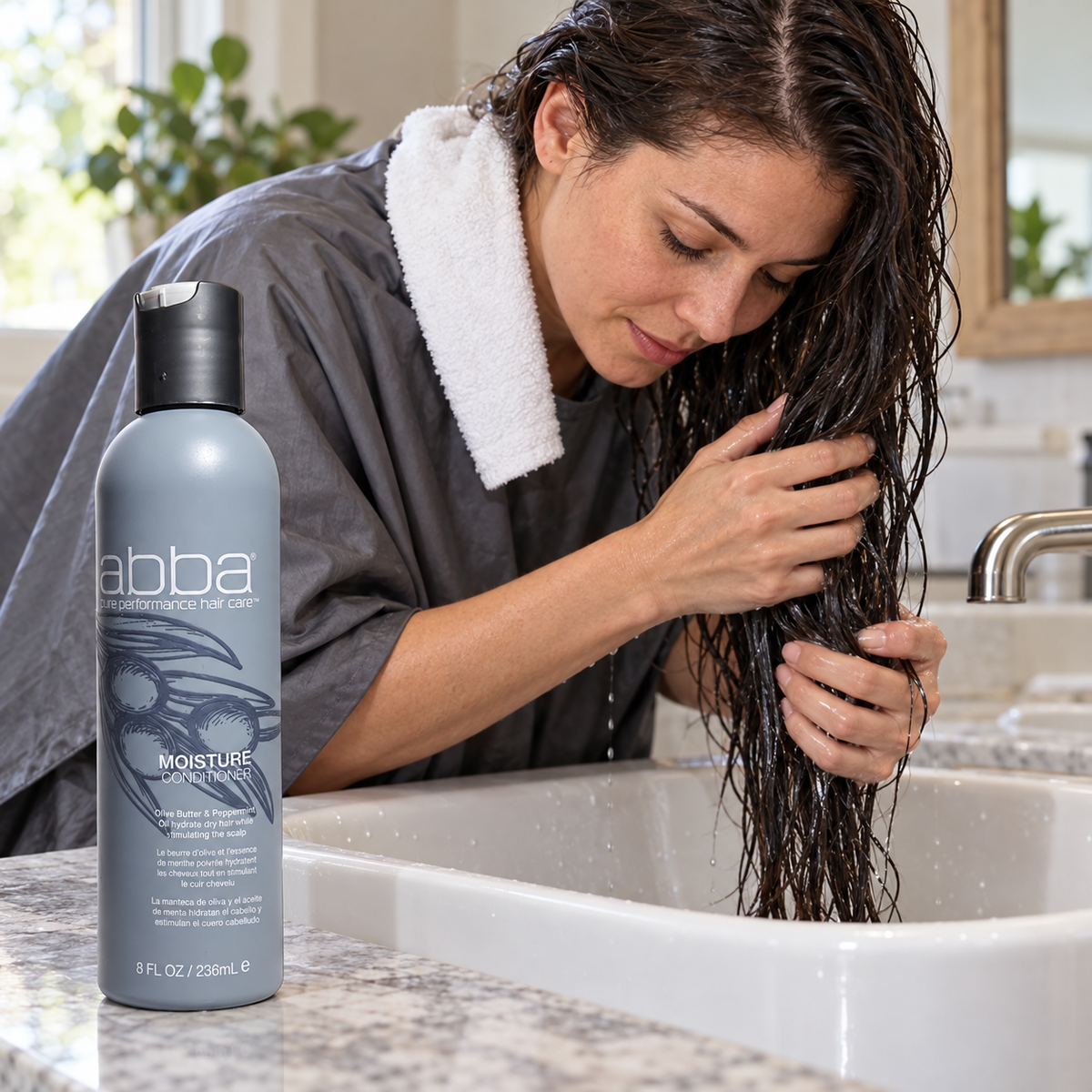 Adult working through wet hair lengths over a basin beside the ABBA Moisture Conditioner 8 fl oz / 236 mL bottle; AI-staged composite.