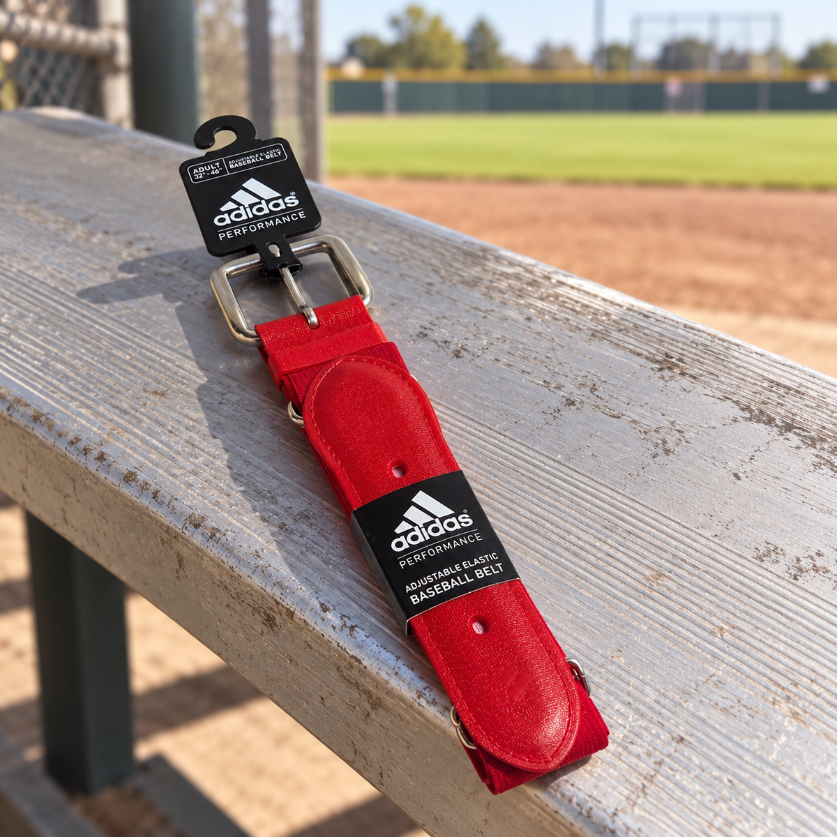 AI-styled red Adidas Performance adult baseball belt with tags on a dugout