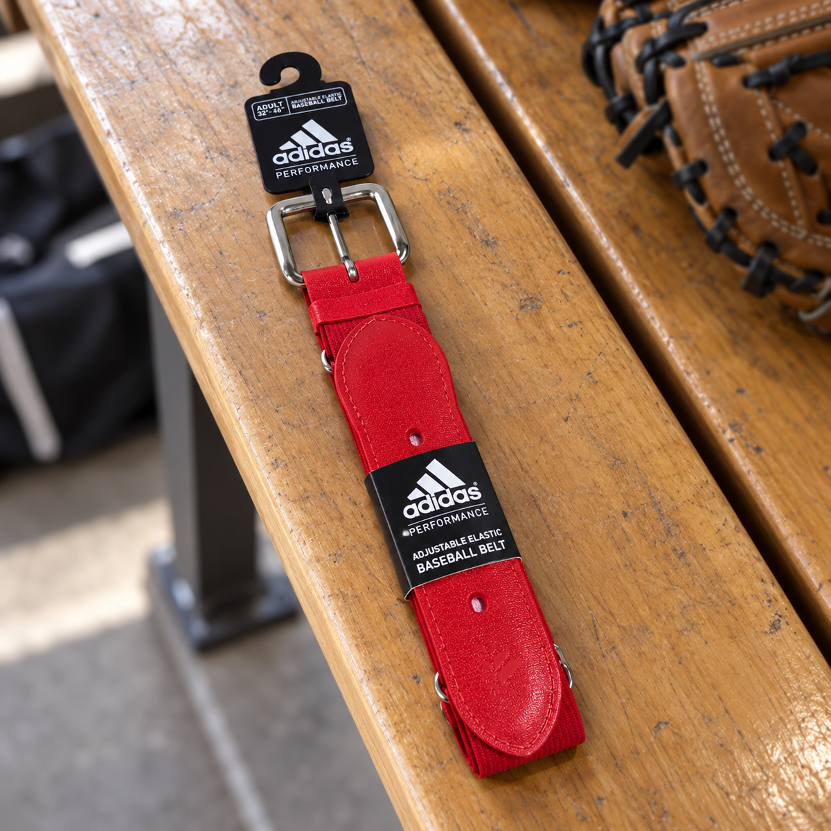 AI-styled red Adidas Performance adult baseball belt with tags on a locker bench