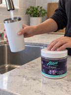 AI-assisted illustration: Filling a tumbler with water beside an Alani Nu Cosmic Stardust tub.