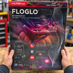 AI-generated scene of adult hands holding the closed Alpena FLOGLO48-inch kit box above a garage workbench.