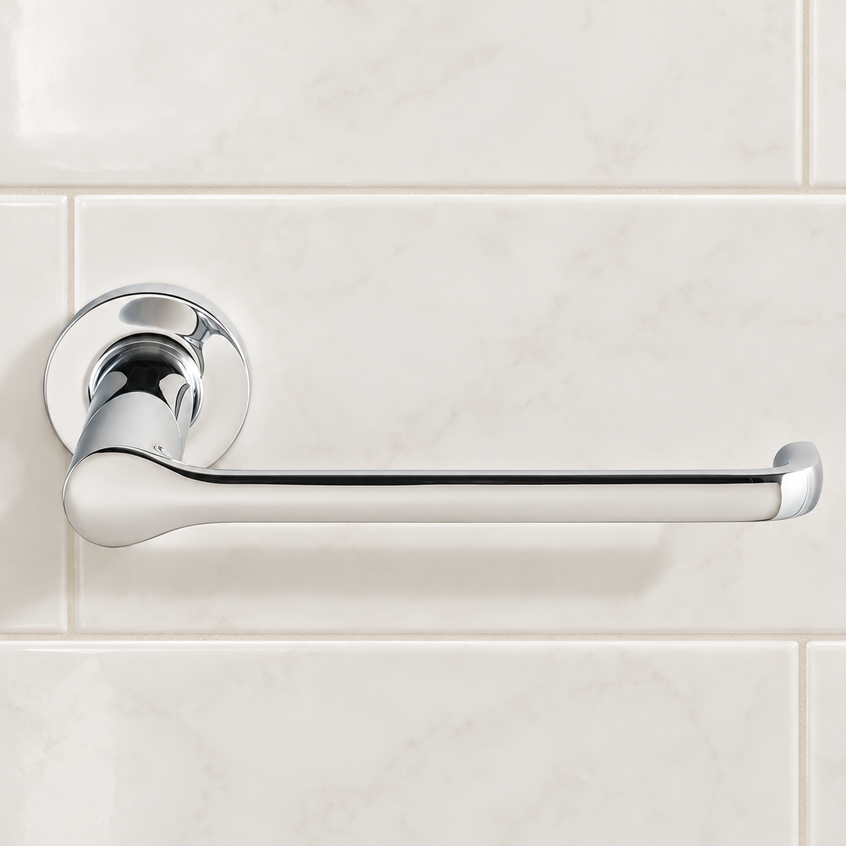 Polished chrome Studio S toilet paper holder mounted on light bathroom tile