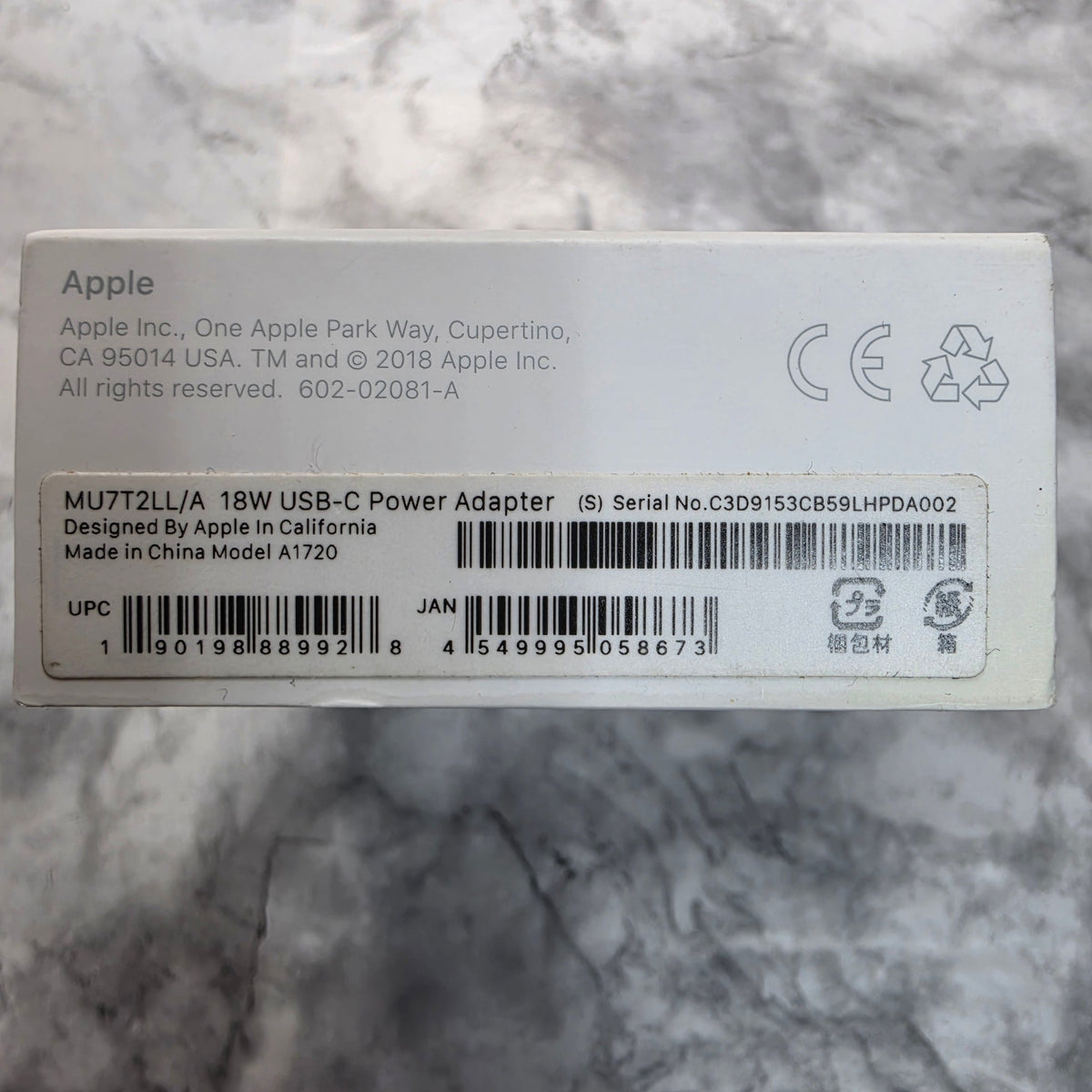 Apple 18W USB-C Power Adapter MU7T2LL/A Model A1720 package label showing UPC 190198889928, JAN 4549995058673 and Made in China