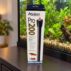 AI-generated lifestyle scene: Aqueon Pro 200W heater retail box on a dry aquarium cabinet; aquarium and props not included.