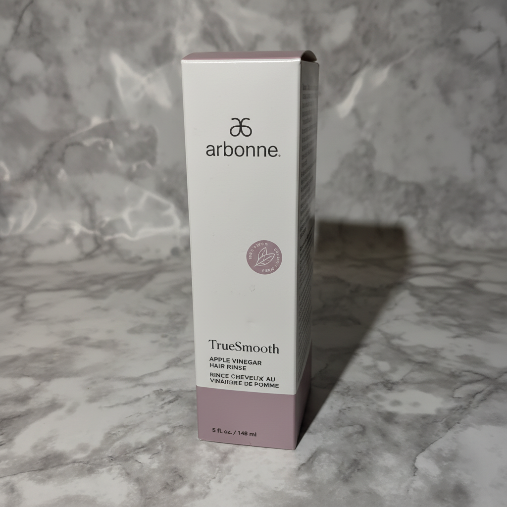 AI-generated contextual image of Arbonne TrueSmooth Apple Vinegar Hair Rinse 5 fl oz boxed product on a neutral marble surface