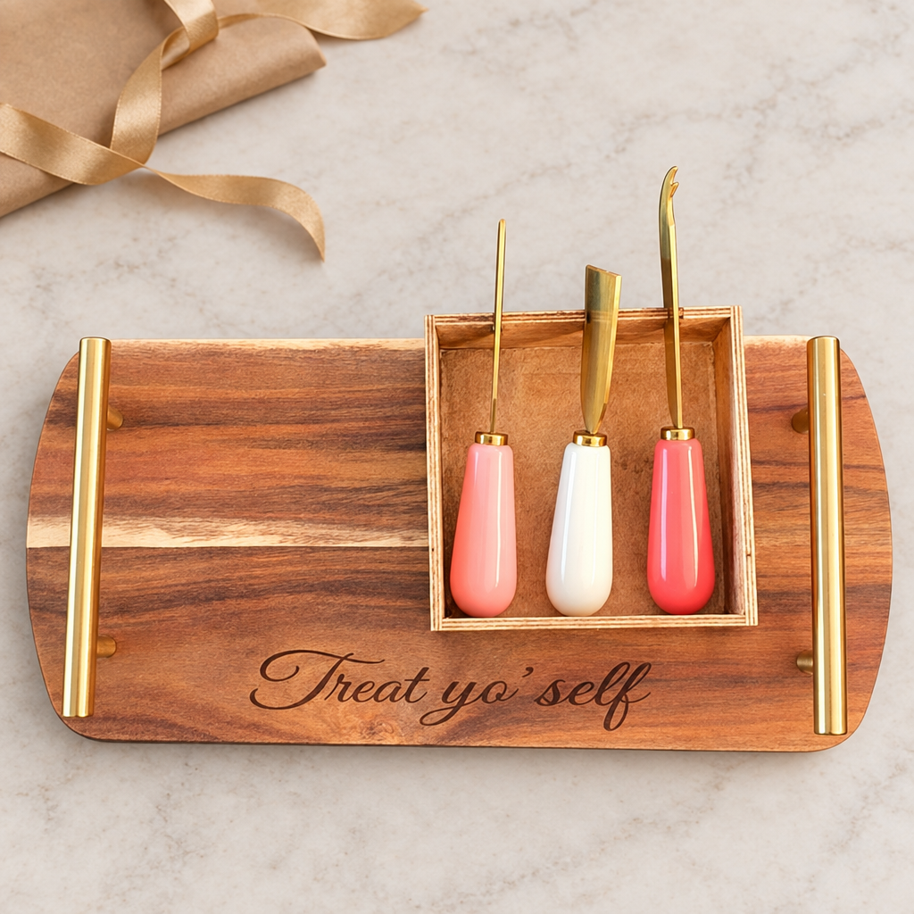 Treat yo’ self engraved acacia cheese tray and three gold-tone tools beside wrapping paper and ribbon