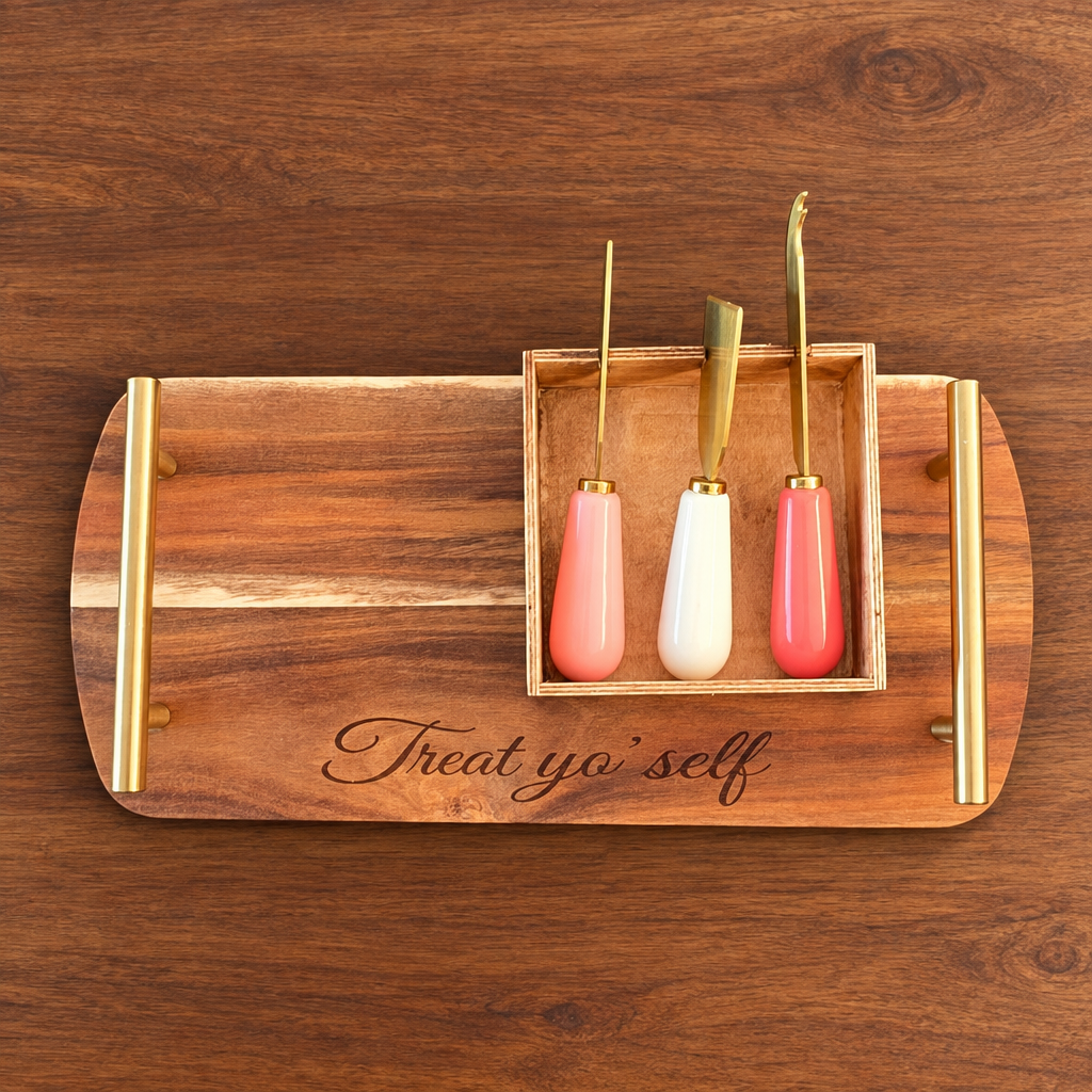Treat yo’ self engraved acacia cheese tray with three gold-tone tools on a wooden dining table