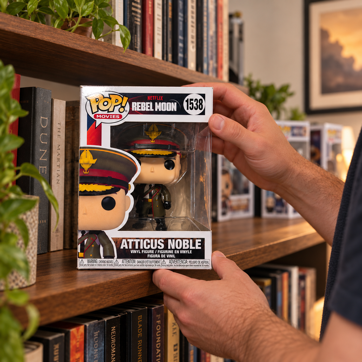 Boxed Funko Pop! Atticus Noble #1538 being placed on a bookshelf.