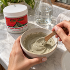 Hands mixing Aztec Secret clay with a wooden utensil in a ceramic bowl