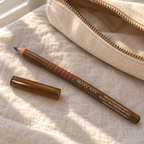 Mary Kay Bahama Blue eyeliner pencil with its cap beside a canvas travel pouch