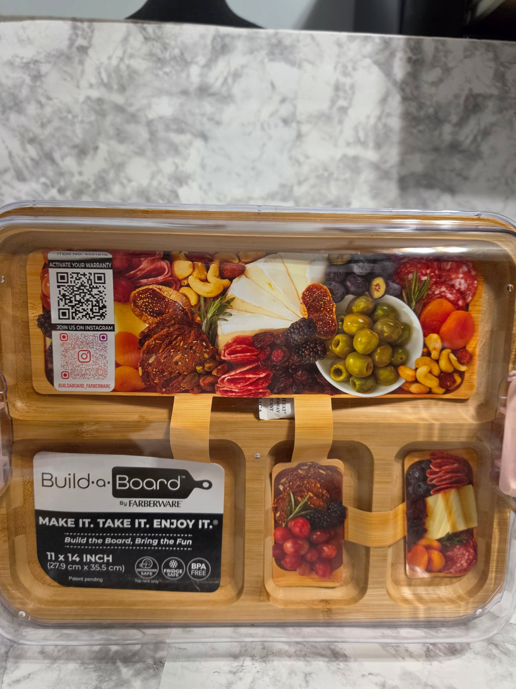 Snack set with various foods in a clear plastic container on a marble surface