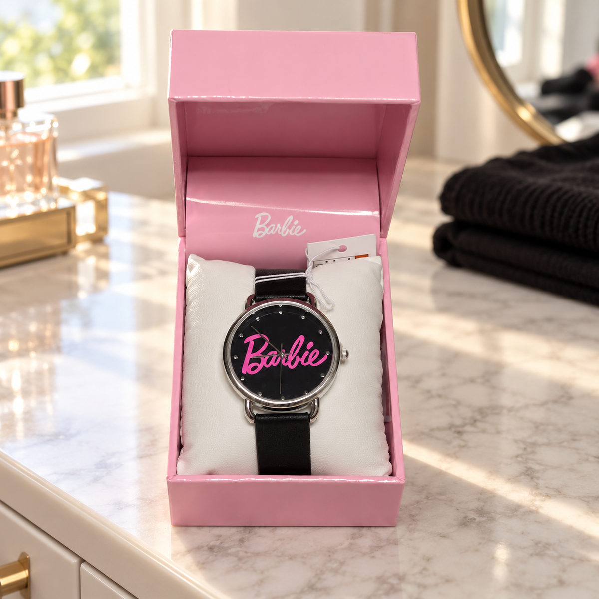 AI illustration of one black-dial pink-script Barbie watch with silver-tone case and black strap in its original presentation box on a home dresser; props not included