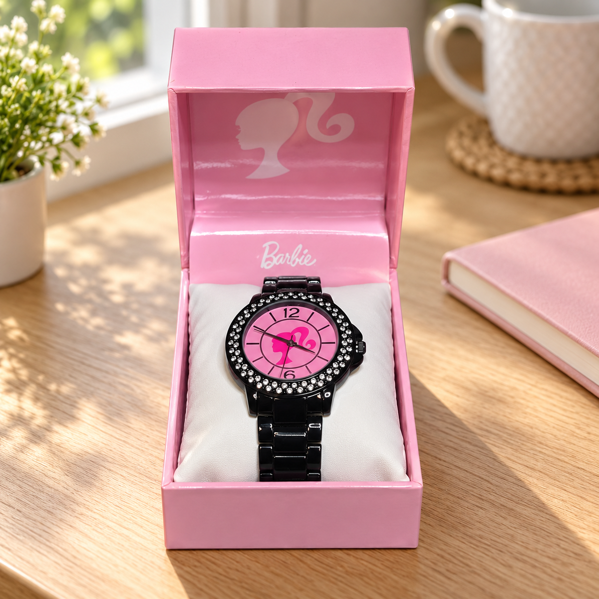 AI illustration of one pink-dial black-link Barbie watch in its presentation box beside reading materials; props not included