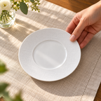 AI-generated illustration of one white Bernardaud Organza breakfast saucer during table placement; other tableware and scene props excluded