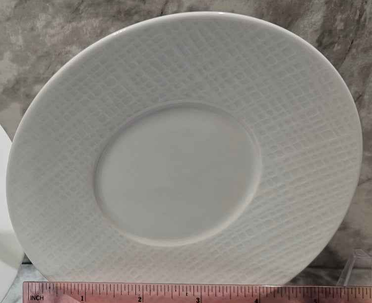 Actual Bernardaud Organza white tea saucer with a woven-texture rim and ruler for scale.