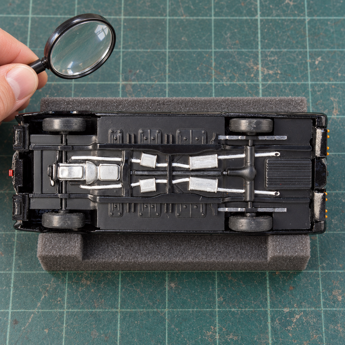 Illustrative underside inspection of an assembled Black Beauty model on a padded hobby mat; inspection props are not included.