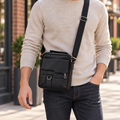 Black textured crossbody bag worn with its adjustable shoulder strap