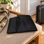 AI-generated entryway-bench scene of the black folded travel bag; jacket and suitcase are not included.