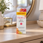Burt's Bees Truly Glowing Glow Booster carton on a bedroom dresser, AI-assisted illustration