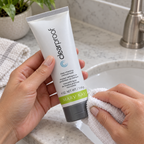 Wiping the closed cap of a Mary Kay Clear Proof charcoal mask tube with a washcloth