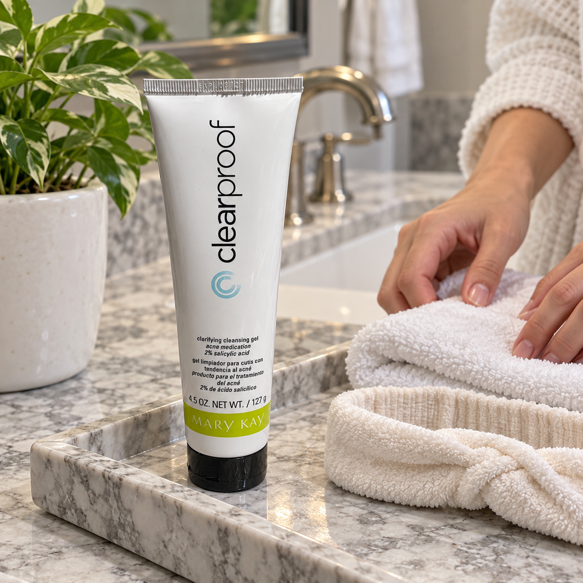 Capped Clear Proof cleansing gel beside a washcloth and headband on a vanity tray