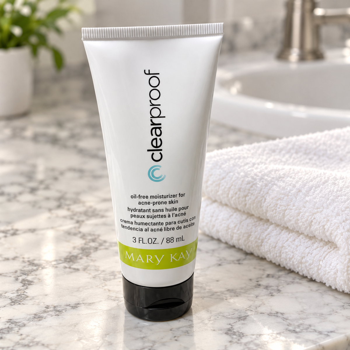 Mary Kay Clear Proof Oil-Free Moisturizer tube beside a folded towel on a marble bathroom counter.