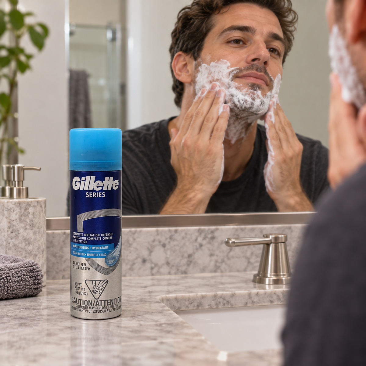 Applying shaving lather with the cocoa butter gel can beside the sink