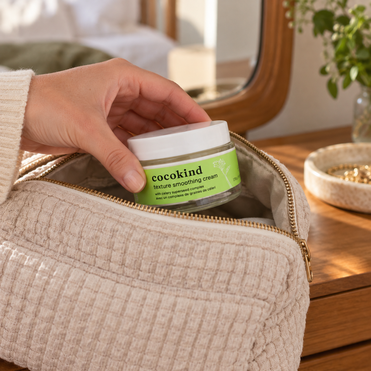 Cocokind Texture Smoothing Cream jar being packed in a fabric toiletry bag