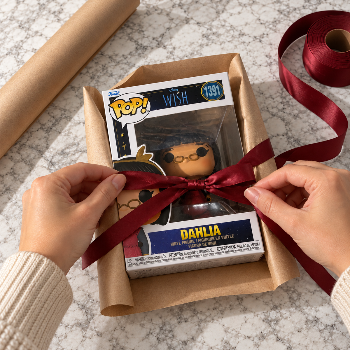 Boxed Funko Pop! Dahlia #1391 being wrapped with a ribbon.