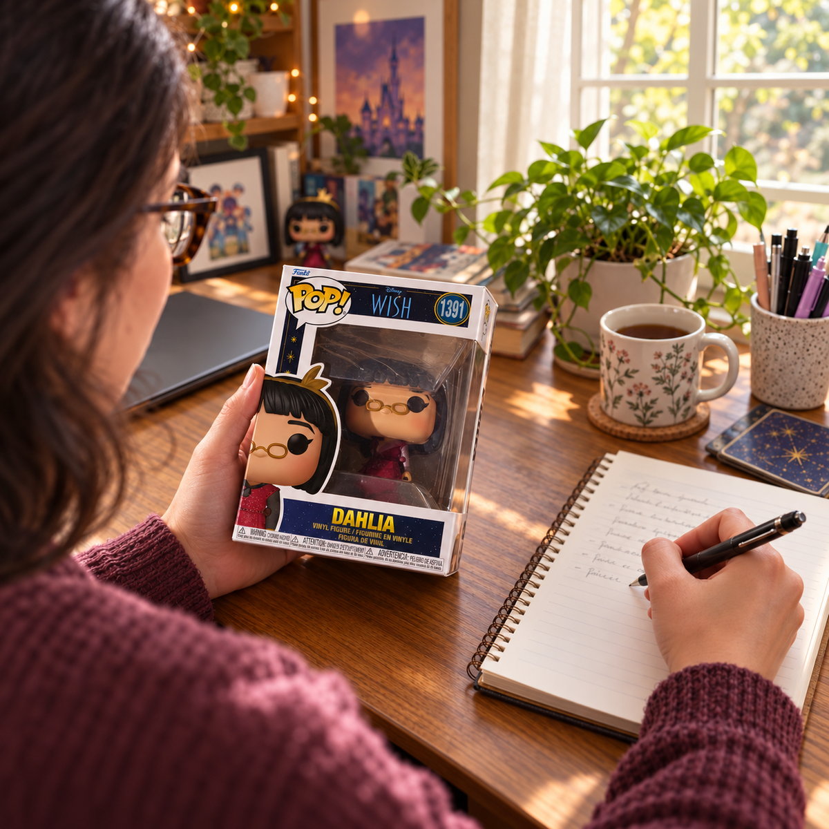 Boxed Funko Pop! Dahlia #1391 being held beside a collector’s notebook.
