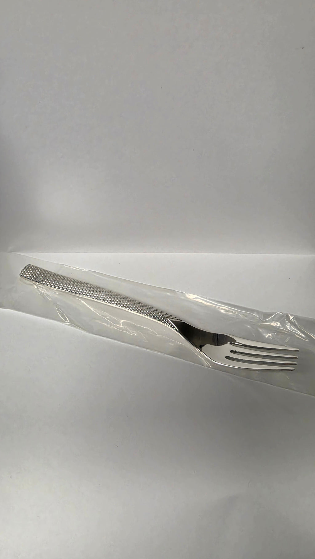 Actual Guy Degrenne Guest Star dessert fork with textured handle in its protective sleeve