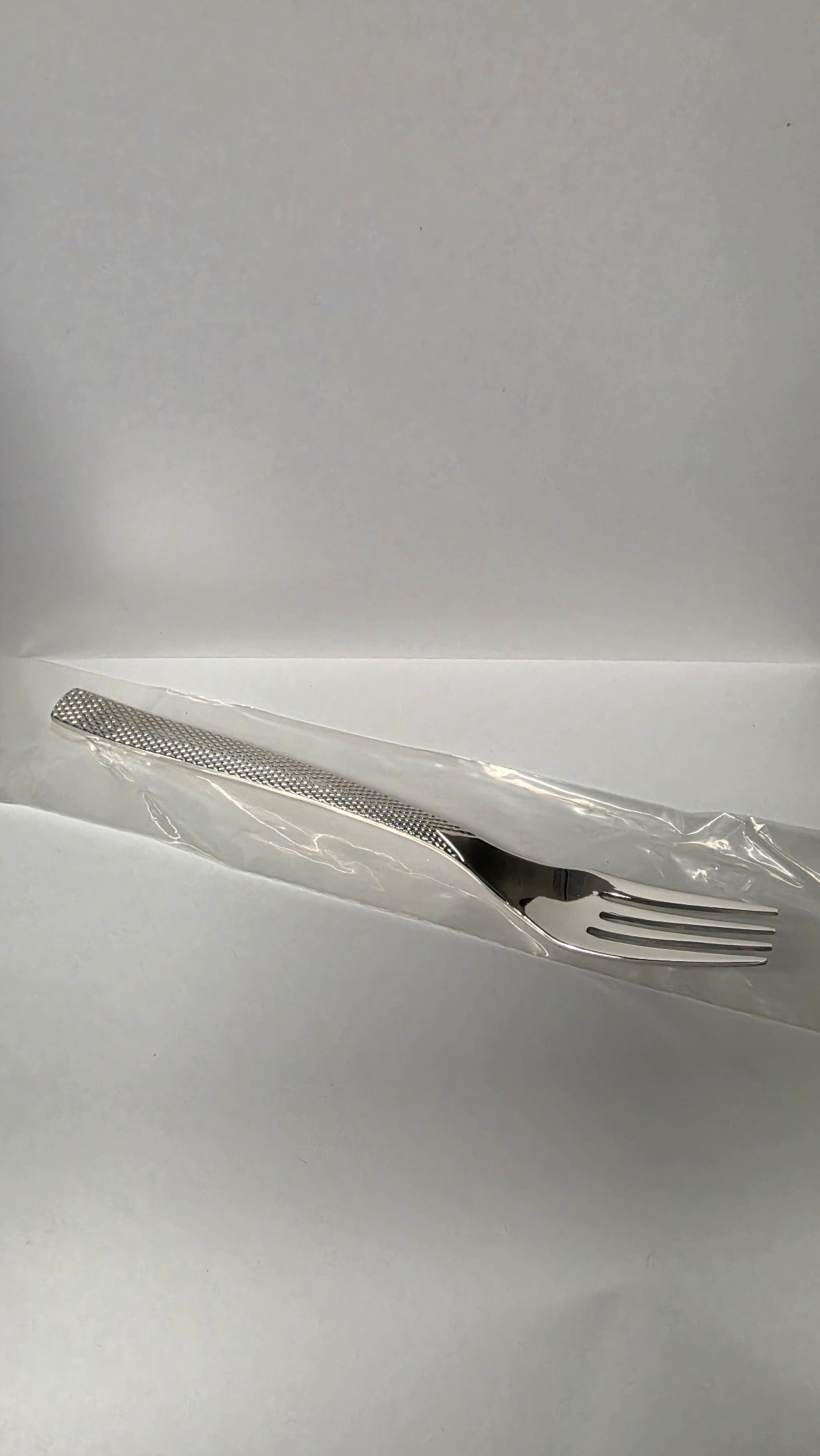 Actual Guy Degrenne Guest Star dessert fork with textured handle in its protective sleeve