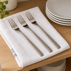 Three sample Guest Star dessert forks on a kitchen towel