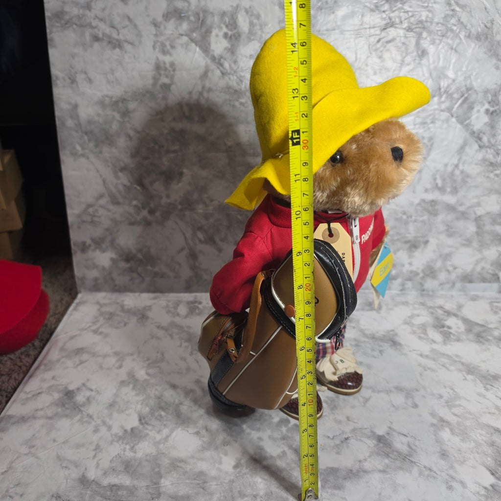 Actual Paddington golfer bear with golf bag photographed beside measuring tape
