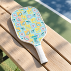AI-generated courtside bench scene with the pastel fruit paddle and white grip.
